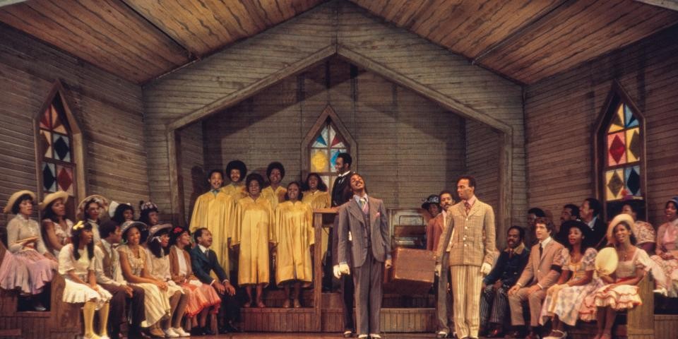 Color photo of people singing on stage in a church.