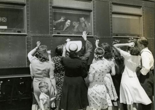 Merle Oberon and McHugh wave goodbye to fans