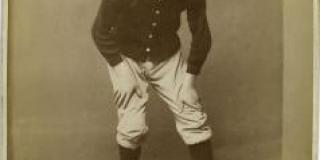 An 1885 albumen silver print of baseball player Joe Mulvey shows him crouching to catch an incoming ball