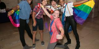 Photo from NYPL's Anti-Prom featuring a group of teens posing with rainbow flags
