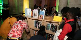Photo from NYPL's Anti-Prom featuring teens looking at bookshelves