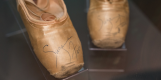 Photo of historic pink ballet shoes with an autograph on the toe of each shoe