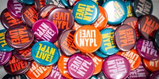 Photo of a messy pile of colorful LIVE from NYPL logo buttons. 