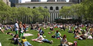 Bryant Park lawn full of people on a summer day.