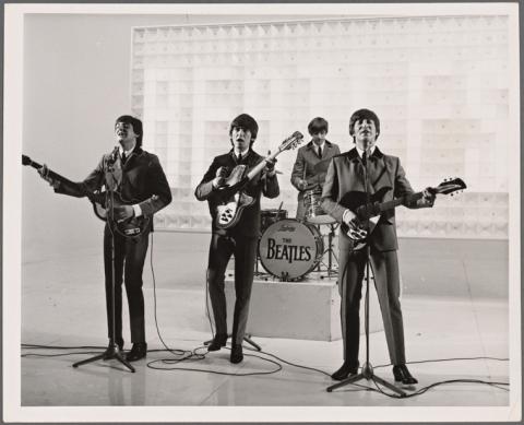 The Beatles perform on a studio set in 1964, the photograph is a still from the film A Hard Day's Night