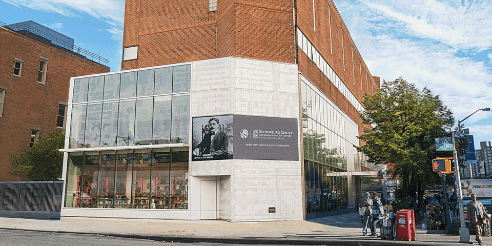Exterior of the Schomburg Center with a sign displaying a photo of Arturo Schomburg.