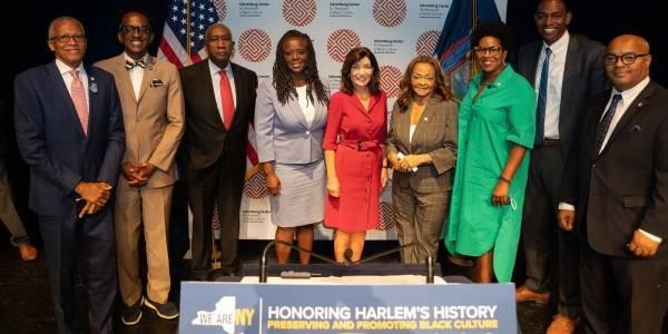 A group shot of New York elected officials. Gov. Kathy Hochul, Assemblymember Inez Dickens, and Schomburg Center Director Joy Bivins are in the Center