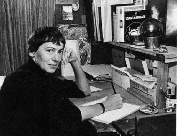 Black and white photo of Ursula K. Le Guin sat at a desk