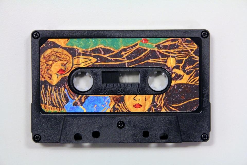 A black cassette tape with designs on the cover
