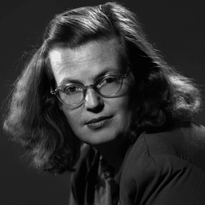 a black and white headshot of Shirley Jackson, wearing glasses and shoulder-length hair