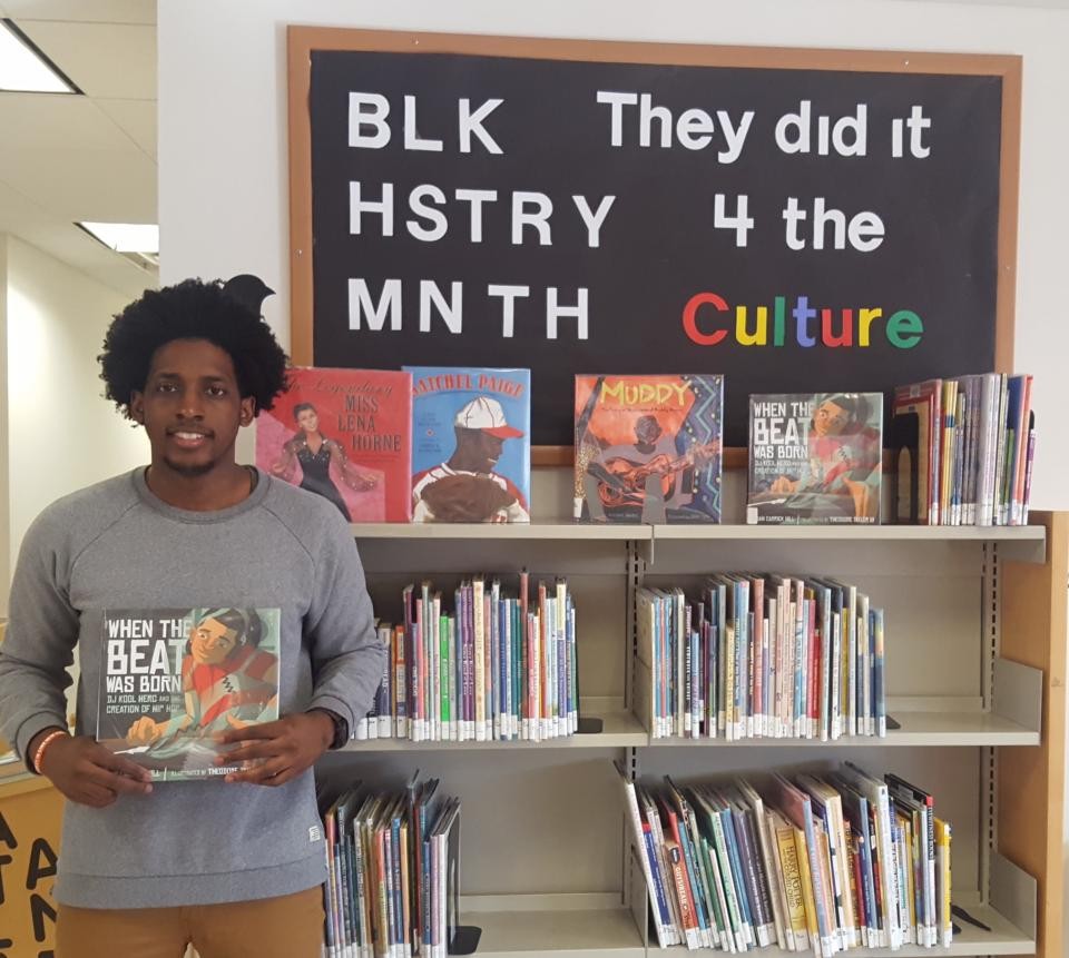 Parkchester Library Trainee Jermaine Dennis holding 