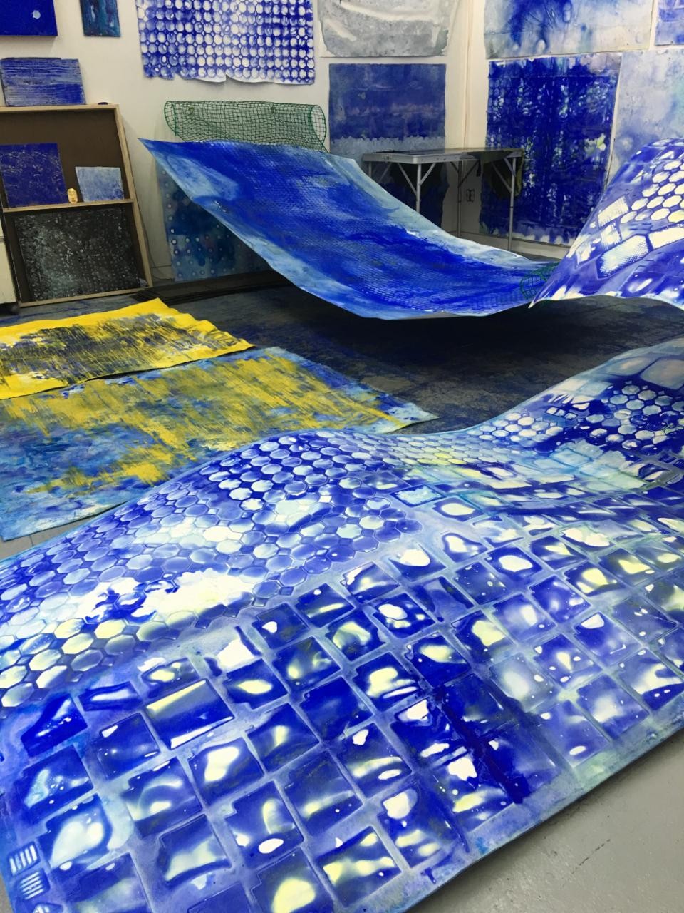 colabt blue paintings on floor of studio