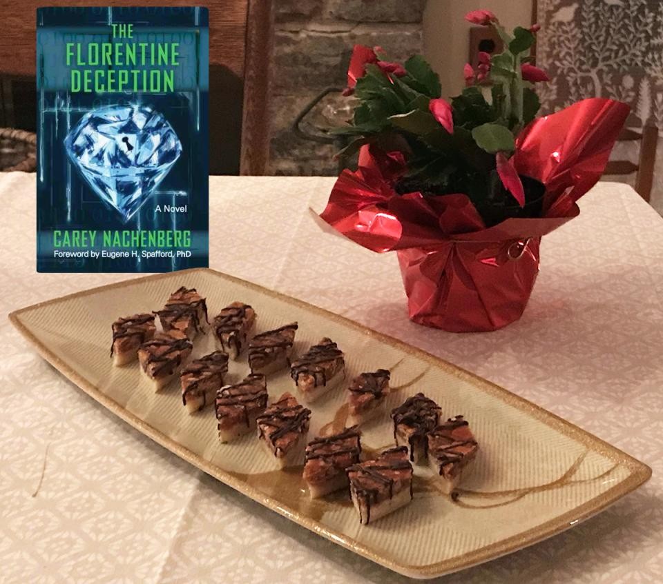 A plate of pastries with a gooey topping and a copy of the book The Florentine Deception