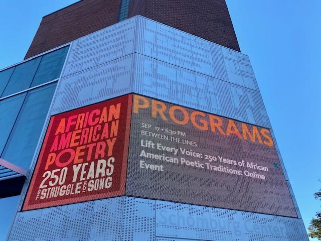 Against the side of a wall, a large image of the book cover African American Poetry: 250 Years of Struggle & Song