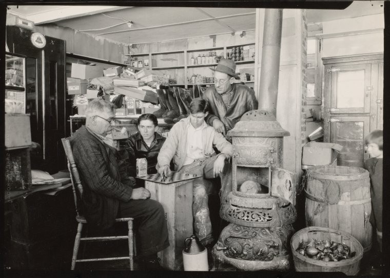 Black-and-white photo of a friendly game by the pot-bellied stove in the country store, upstate New York