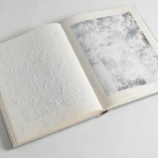 Open book with textured pages.