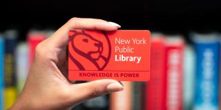 Photo of a hand holding a NYPL library card
