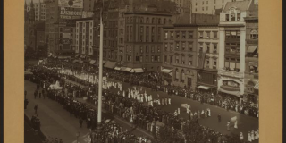 Black-and-white photograph taken from a high vantage point of a parade of suffragists on Fifth Avenue in New York in 1913.