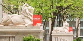 Statues of lions reading red books outside of NYPL building at 42nd Street
