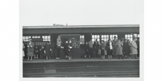 Historic photo of people waiting for a train on an elevated subway platform