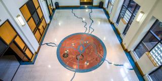 Interior of the Schomburg Center, featuring the Langston Hughes Lobby's terrazzo floor, which is marked by a brass cosmogram bearing song lines, texts, and literary signs 