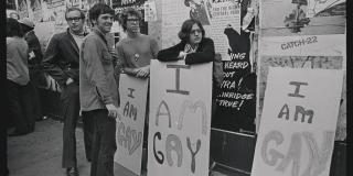 Group of people holding signs saying "I Am Gay"