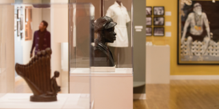 Photo of an exhibition at the Schomburg Center, featuring several sculptures inside of glass cases