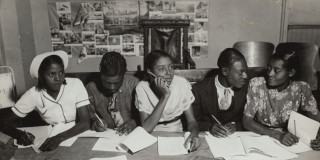 Historic photo of a group of Black teenagers sitting at a table and doing schoolwork