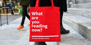 Closeup of a red NYPL tote bag that reads: What are you reading now?