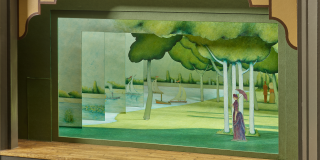 Set model for the Broadway production of Sunday in the Park with George;  scene shows a woman standing on her own in a lush green park
