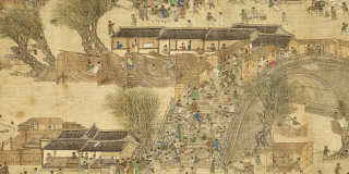 A scroll showing a highly detailed outdoor scene. Small figures—some alone or in pairs, some in large clusters—are set against a backdrop of houses, trees, and architecture, along the banks of a river. Pigment on silk.