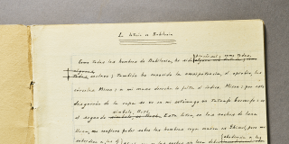 Jorge Luis Borges's manuscript draft of "La lotería en Babilonia" on a notebook open to show the first page of his writing.
