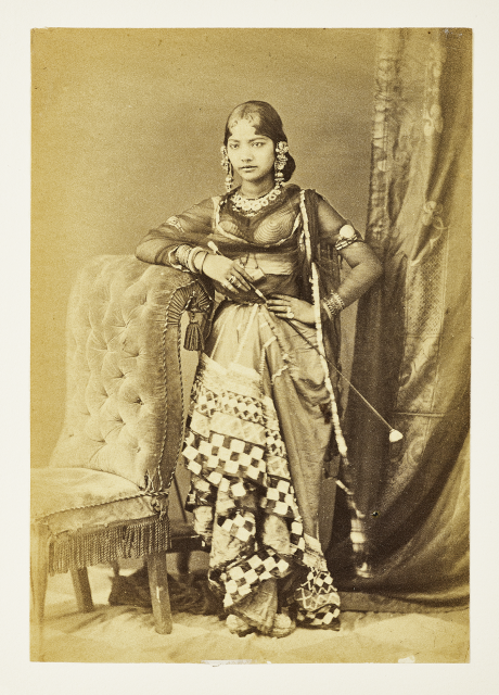 Black and white photograph of a woman in ornate dress