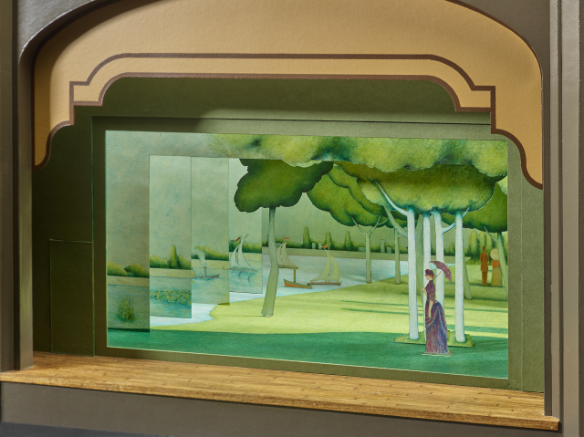 Set model for the Broadway production of Sunday in the Park with George;  scene shows a woman standing on her own in a lush green park