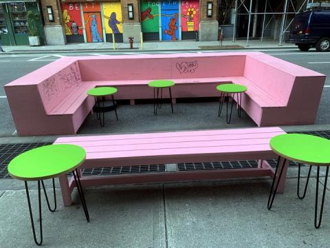 A colorful outdoor dining space with benches and tables